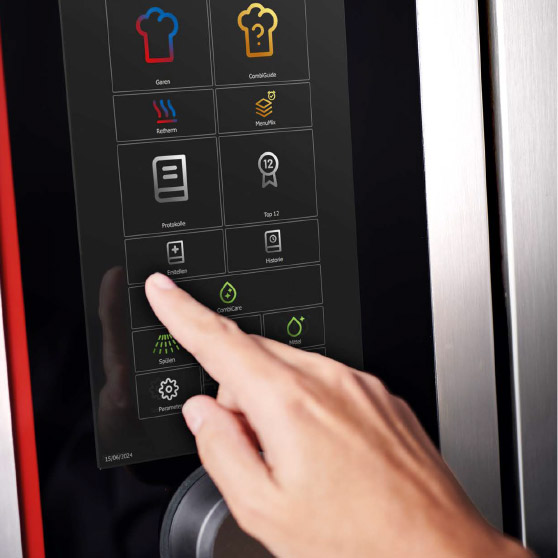 Zbliżenie palca obsługującego menu dotykowe z różnymi ikonami funkcji, takimi jak gotowanie, CombiGuide, Retherm, MenuPlus, protokoły, ustawienia i czyszczenie.