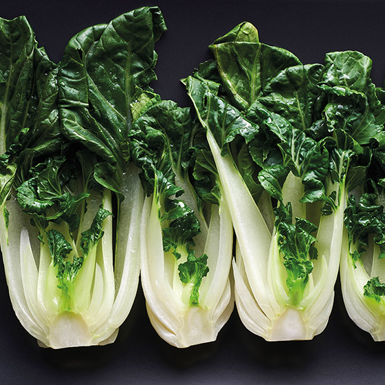 Cztery świeże główki bok choy z białymi łodygami i zielonymi liśćmi – delikatnie przygotowane dzięki CHEF'S COMBI od HOBART, aby zachować świeżość i wartości odżywcze.