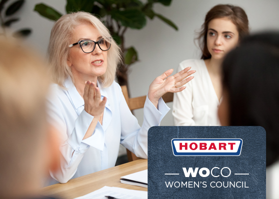 Spotkanie w biurze z naciskiem na HOBART Women’s Council (WOCO), inicjatywę wspierającą kobiety i równość w firmie. Na stole znajdują się dokumenty i przybory do pisania.