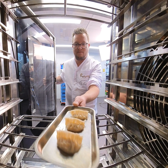 Blacha z przygotowaną potrawą jest wsuwana do komory urządzenia HOBART CHEF’S COMBI, ukazana z perspektywy wnętrza urządzenia.